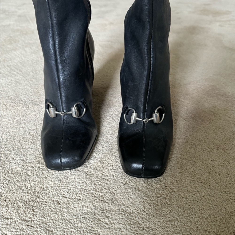 Black Leather heeled boots with bit detail on instep.